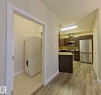Dedicated laundry area with stacked appliances and tiled flooring - 108 9603 98 Avenue Nw, Edmonton, AB  - Indoor 