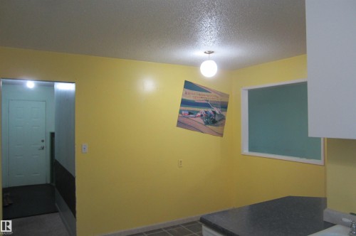 Kitchen space featuring bright yellow walls, a window with white trim, and a dark countertop - 3814 37 Avenue, Leduc, AB - Indoor Photo Showing Other Room