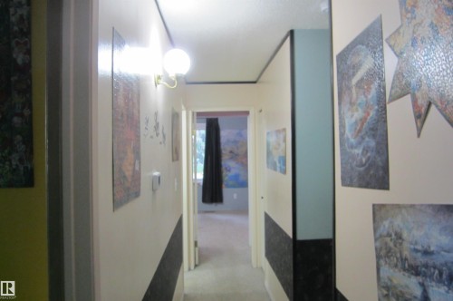 Hallway with a wall-mounted globe light fixture and light-colored walls - 3814 37 Avenue, Leduc, AB - Indoor