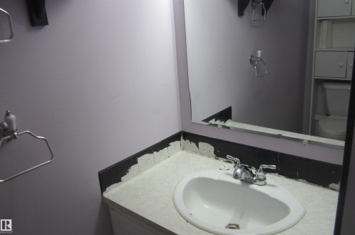 White countertop with an integrated basin sink and chrome faucet - 3814 37 Avenue, Leduc, AB - Indoor Photo Showing Bathroom
