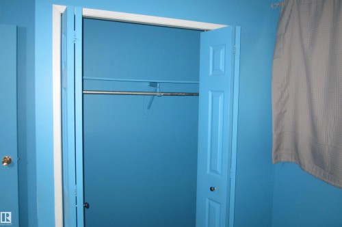 Recessed closet with bifold panel doors and interior hanging rod - 3814 37 Avenue, Leduc, AB - Indoor