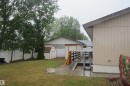 Expansive backyard featuring mature trees, a white perimeter fence, and a storage shed with a shingle roof - 3814 37 Avenue, Leduc, AB  - Outdoor 