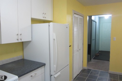 Kitchen featuring white cabinetry, dark gray countertops, and tile flooring - 3814 37 Avenue, Leduc, AB - Indoor