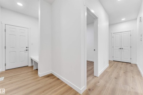 Open concept entryway featuring wood-finish flooring, recessed lighting, and a built-in bench - 1972 210 Street, Edmonton, AB - Indoor Photo Showing Other Room