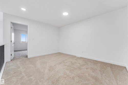 Neutral-toned carpeting and white walls define this flexible room - 1972 210 Street, Edmonton, AB - Indoor Photo Showing Other Room