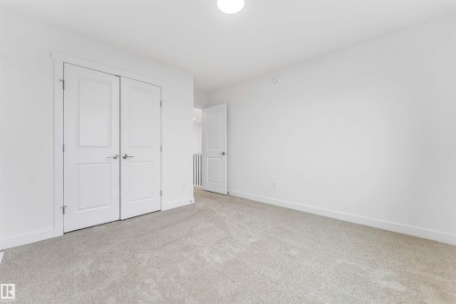Carpeted room featuring white walls, white baseboards, a white ceiling, and a white flush-mount ceiling light - 1972 210 Street, Edmonton, AB - Indoor Photo Showing Other Room