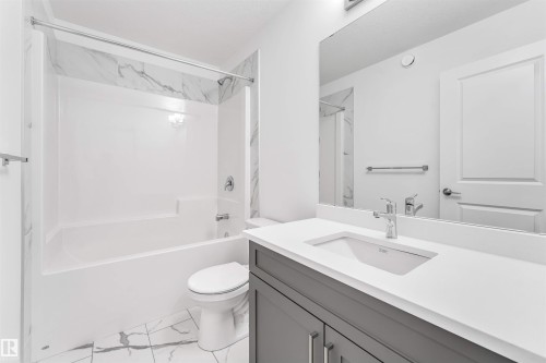 Bathroom featuring a white vanity with a light countertop, an undermount sink, and polished chrome fixtures - 1972 210 Street, Edmonton, AB - Indoor Photo Showing Bathroom