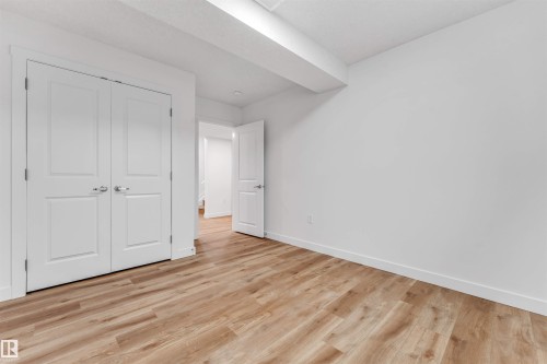 Room featuring wood-finish flooring, white walls, white baseboards, and a white ceiling - 1972 210 Street, Edmonton, AB - Indoor Photo Showing Other Room