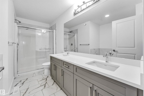 Spacious bathroom featuring a dual vanity with grey cabinetry and white countertops - 1972 210 Street, Edmonton, AB - Indoor Photo Showing Bathroom