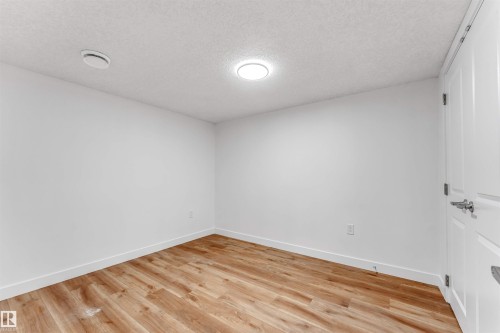 Bright room featuring wood-finish flooring, crisp white walls, and a recessed ceiling light - 1972 210 Street, Edmonton, AB - Indoor Photo Showing Other Room