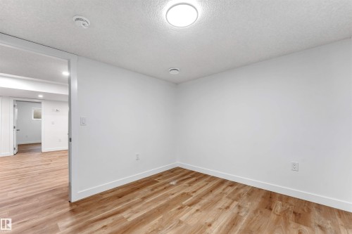 Spacious room featuring wood-finish flooring, crisp white walls, and recessed lighting - 1972 210 Street, Edmonton, AB - Indoor Photo Showing Other Room