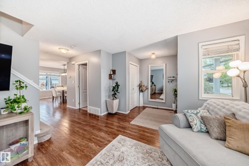 Open-concept living space with wood-finish flooring extending into the dining area - 17233 88 Street, Edmonton, AB - Indoor Photo Showing Living Room