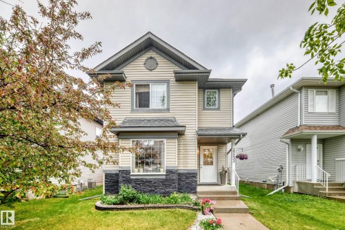 Two-story residence featuring light-colored siding, a stone facade accent, and dark shingle roofing - 17233 88 Street, Edmonton, AB - Outdoor With Facade