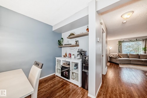 Built-in beverage station featuring a white cabinet with glass doors, open shelving, and integrated mini-refrigerator - 17233 88 Street, Edmonton, AB - Indoor