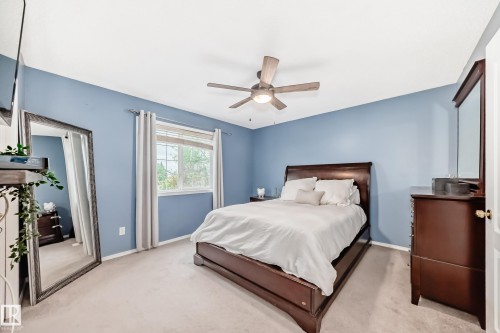 Bedroom featuring light blue walls, soft carpeting, a window with horizontal blinds, and a ceiling fan with integrated lighting - 17233 88 Street, Edmonton, AB - Indoor Photo Showing Bedroom