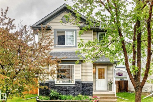 Two-story residence featuring light-toned siding and a contrasting dark stone facade - 17233 88 Street, Edmonton, AB - Outdoor