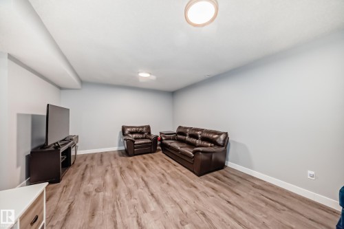 Spacious room featuring wood-finish flooring, light gray walls, white baseboards, and ceiling-mounted flush lighting - 17233 88 Street, Edmonton, AB - Indoor Photo Showing Other Room