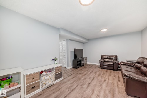 Spacious interior featuring wood-finish flooring, light gray walls, and recessed lighting - 17233 88 Street, Edmonton, AB - Indoor