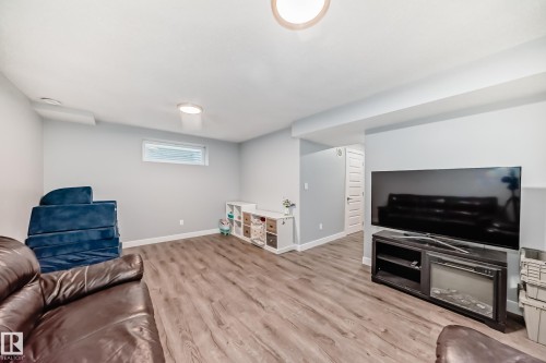 Spacious room featuring wood-finish flooring, light gray walls, and recessed lighting - 17233 88 Street, Edmonton, AB - Indoor