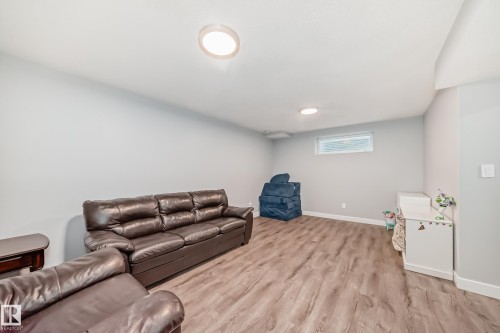 Spacious room featuring wood-finish flooring, light grey painted walls, white baseboards, and two recessed ceiling lights - 17233 88 Street, Edmonton, AB - Indoor Photo Showing Basement