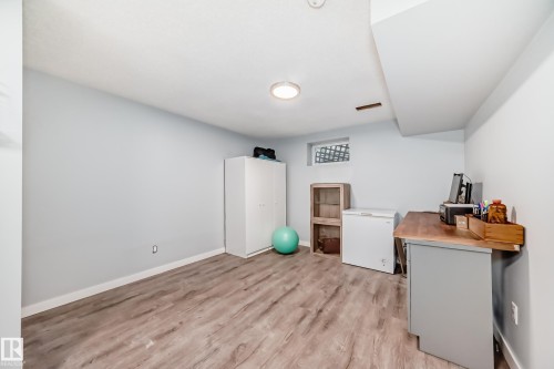 Finished room with wood-finish flooring, light gray wall paint, and white baseboards - 17233 88 Street, Edmonton, AB - Indoor