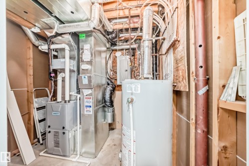 Dedicated utility space featuring a water heater, furnace, and exposed ductwork - 17233 88 Street, Edmonton, AB - Indoor Photo Showing Basement