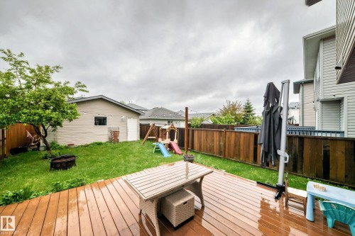 Expansive backyard featuring a wood-finish deck, a detached shed, a fire pit, and privacy fencing - 17233 88 Street, Edmonton, AB - Outdoor With Deck Patio Veranda With Exterior