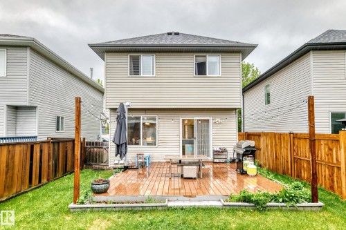 Expansive backyard featuring a wood-finish deck, manicured lawn, and privacy fencing - 17233 88 Street, Edmonton, AB - Outdoor With Exterior