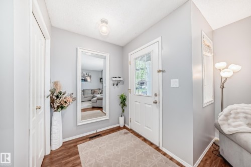 Entryway featuring wood-finish flooring, light grey wall paint, and a built-in closet with a white panel door - 17233 88 Street, Edmonton, AB - Indoor Photo Showing Other Room