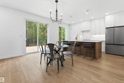 Open-concept kitchen and dining area featuring light wood-finish flooring - 