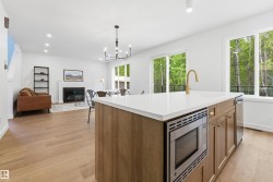 Kitchen island with a built-in microwave, a gold-tone faucet, and an undermount sink - 