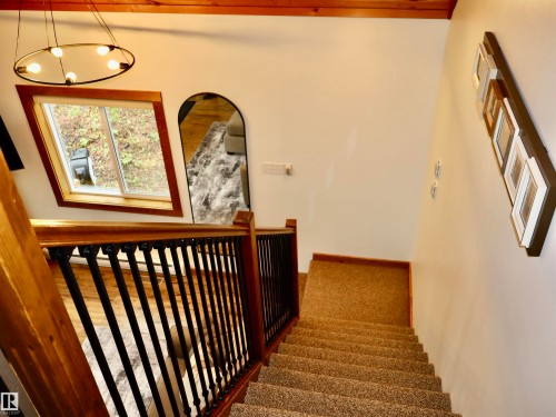 Carpeted staircase with light-toned walls and wood trim - #20 59316 Rr 54, Rural Barrhead County, AB 