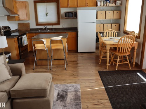 Open-concept kitchen and dining area featuring wood-finish flooring - #20 59316 Rr 54, Rural Barrhead County, AB 
