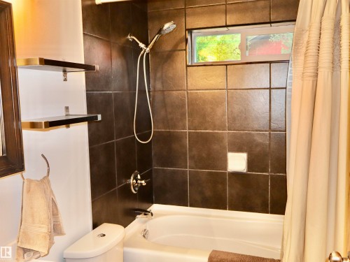 Shower-over-tub combination with dark wall tiling and chrome fixtures - #20 59316 Rr 54, Rural Barrhead County, AB 