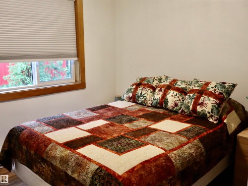 Single-hung window with a wood-finish frame and cellular shade - #20 59316 Rr 54, Rural Barrhead County, AB 