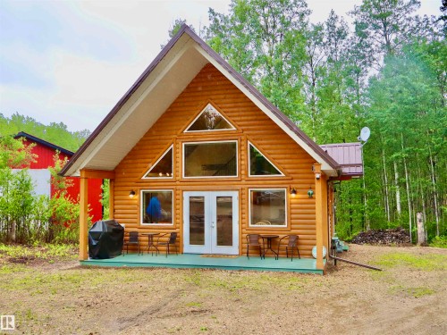 Wood-sided A-frame structure with a metal roof and a prominent wall of windows - #20 59316 Rr 54, Rural Barrhead County, AB 