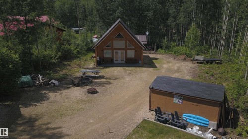 A-frame style cabin featuring a natural wood exterior and a prominent triangular window design - #20 59316 Rr 54, Rural Barrhead County, AB 
