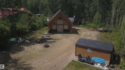 A-frame style cabin featuring a natural wood exterior and a prominent triangular window design - 