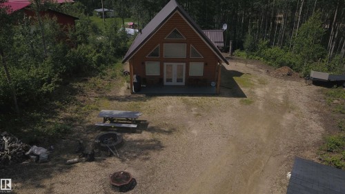 Wood-sided cabin featuring a steeply pitched roof and a front patio - #20 59316 Rr 54, Rural Barrhead County, AB 