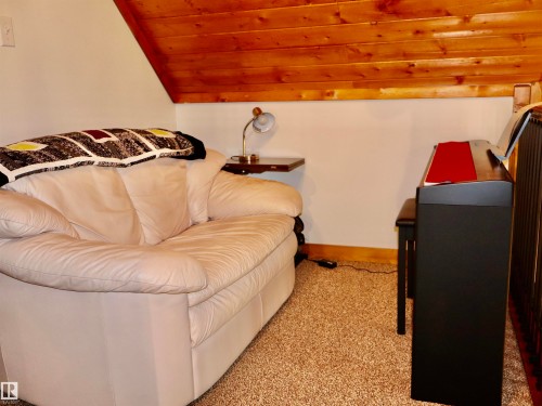 Angled wall with wood-finish ceiling, light-toned walls, and neutral carpet flooring - #20 59316 Rr 54, Rural Barrhead County, AB 