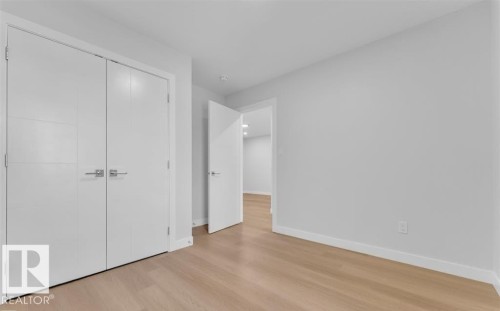 Room featuring wood-finish flooring, light grey walls, and white trim - 3025 39 Avenue, Beaumont, AB - Indoor Photo Showing Other Room
