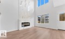 Vaulted ceiling living area featuring a full-height marble-look fireplace surround with an electric insert - 3025 39 Avenue, Beaumont, AB  - Indoor Photo Showing Living Room With Fireplace 