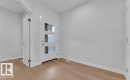 Entryway featuring a white door with three frosted glass panels, light wood-finish flooring, and white baseboards - 3025 39 Avenue, Beaumont, AB  - Indoor Photo Showing Other Room 