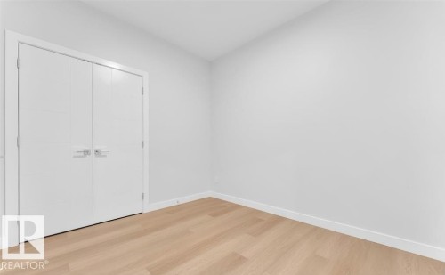 Wood-finish flooring and white walls - 3025 39 Avenue, Beaumont, AB - Indoor Photo Showing Other Room