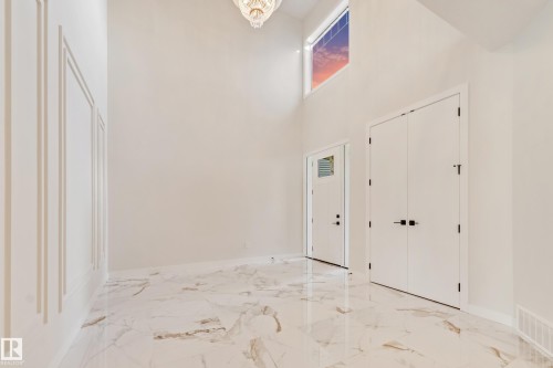 Grand foyer featuring high ceilings, a prominent chandelier, and a large transom window - 4015 39 Street, Beaumont, AB - Indoor Photo Showing Other Room