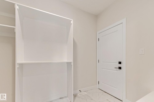 Built-in shelving unit with white finish, complementing the white shaker-style door with matte black hardware - 4015 39 Street, Beaumont, AB - Indoor