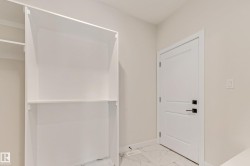 Built-in shelving unit with white finish, complementing the white shaker-style door with matte black hardware - 