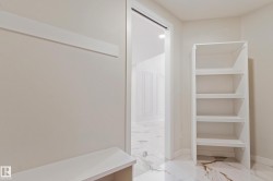 Open doorway revealing an additional room with white paneled walls and marble-style flooring - 
