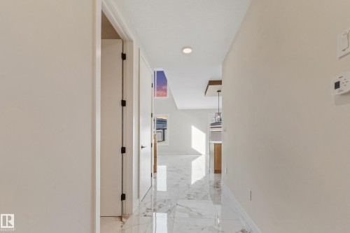 Hallway featuring polished tile flooring, recessed lighting, and crisp white walls - 4015 39 Street, Beaumont, AB - Indoor Photo Showing Other Room