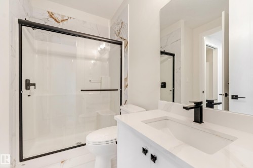 Bathroom featuring a white vanity with an integrated rectangular sink, a black single-handle faucet, and black cabinet hardware - 4015 39 Street, Beaumont, AB - Indoor Photo Showing Bathroom